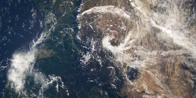 A satellite image showing a large hurricane approaching a coastline, illustrating the increased intensity of storms due to climate change.