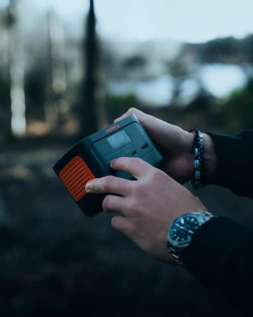 A close-up view of a hand-crank radio and flashlight, highlighting their importance in an emergency weather kit. The devices are in a high-visibility color, such as orange or yellow, and placed on a wooden surface.
