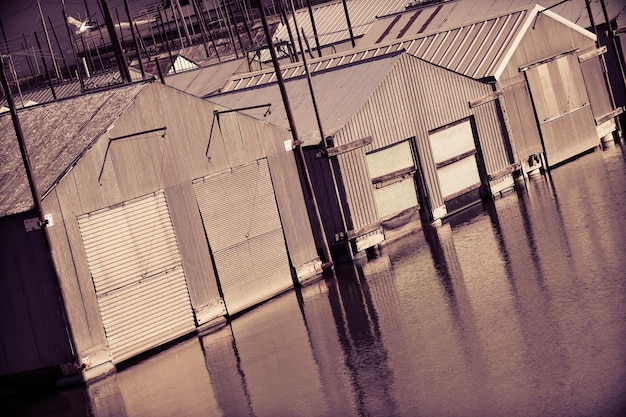 A flooded main street of a small town, with businesses shuttered and vehicles partially submerged, illustrating the economic disruption caused by flooding.