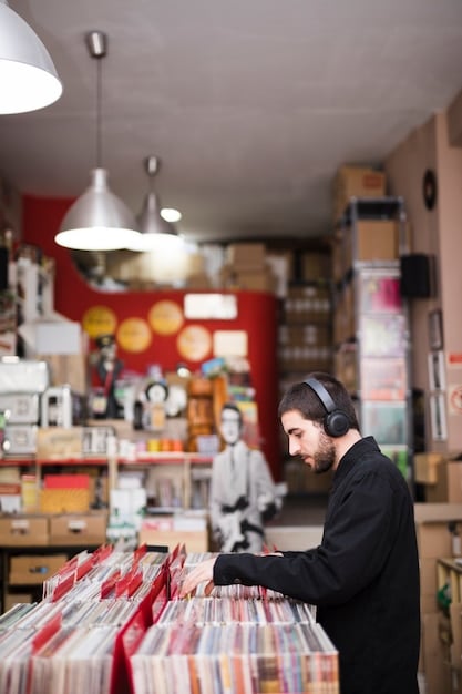 A vintage record store in the US, filled with vinyl records and customers browsing. The store has a warm, inviting atmosphere with wooden shelves and posters of classic bands.