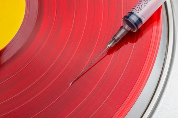 A close-up shot of a vinyl record player's needle dropping onto a record. The background is blurred, with soft lighting highlighting the texture of the vinyl.