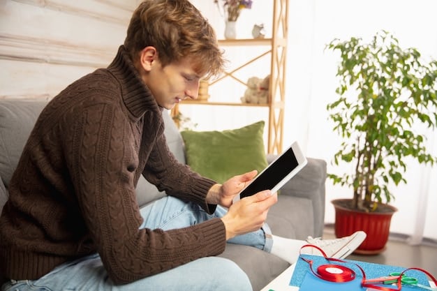 A person checking their blood pressure at home using a digital blood pressure monitor. A notepad and pen are next to the monitor, suggesting they are recording the readings.