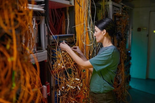 A technician working on fiber optic cables in a data center, illustrating broadband infrastructure.
