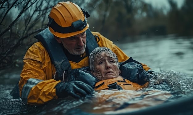 A close-up of a rescue worker helping an elderly person from a partially submerged home, highlighting the human element of disaster relief and the urgency of the situation.