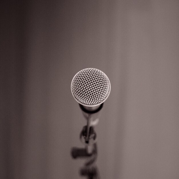 A close-up of a vintage microphone with a warm, inviting glow, casting a soft shadow on a textured background, evoking a sense of captivating storytelling and intimate audio experience.