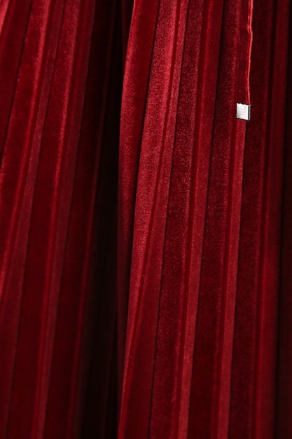 A detailed, high-resolution close-up of a Broadway stage curtain, richly textured, with the distinct theatrical lighting reflecting off its folds, symbolizing anticipation and the magic of the theater.