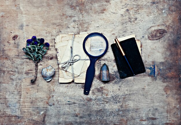A detective's desk cluttered with old case files, a magnifying glass, and a map with pinned locations, suggesting a complex, long-running investigation. The lighting is dim, reflecting the seriousness of true crime.