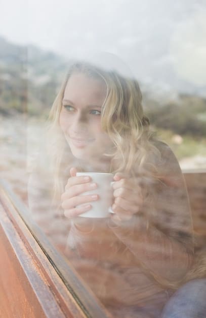 A person enjoying a cup of coffee by a bright window in the morning, with natural light streaming in, symbolizing morning light exposure.