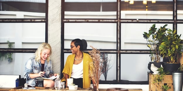 A diverse group of business professionals in a modern office, actively collaborating around a table with laptops and financial charts, symbolizing strategic discussions and planning around new tax policies.