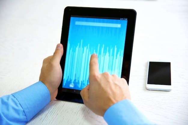 A close-up shot of a hand using a digital tablet to analyze complex financial data visualizations, including charts and graphs, with blurred office workers in the background, signifying detailed financial analysis.