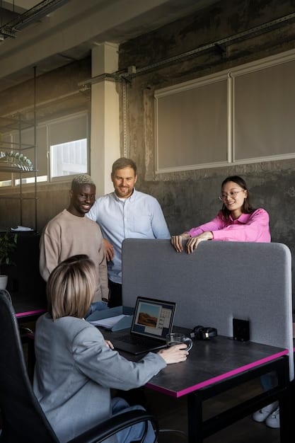 A diverse group of business professionals in a modern office collaborating around a large screen displaying complex financial models and real-time market data, highlighting teamwork and data-driven decisions.