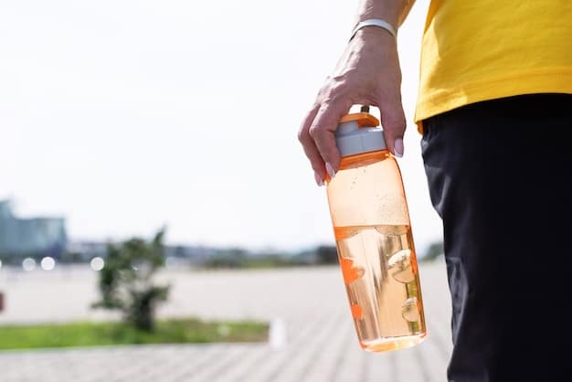 Close-up of a person's hand reaching for a water bottle during a workout, symbolizing the importance of hydration during physical activity. The background blurs to emphasize the action and Stay Hydrated: The Importance of Water and How Much You Really Need in an active lifestyle.