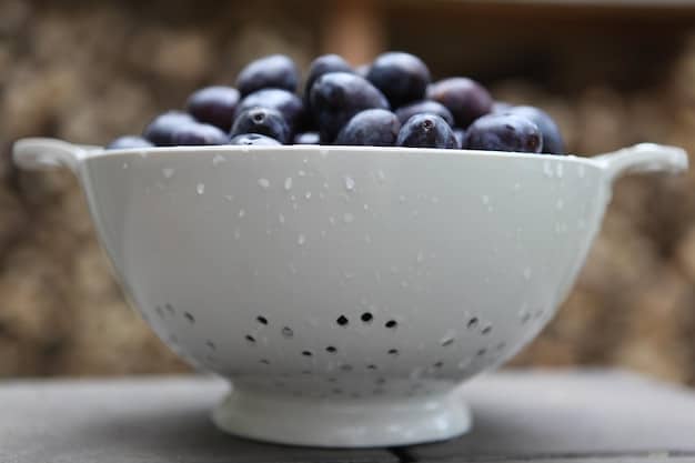 Close-up shot of fresh, ripe blueberries in a ceramic bowl, with a blurred background of a sunny kitchen. Focus is on the vibrant color and texture of the blueberries, emphasizing their appeal as a brain-boosting food. Highlighting the benefits of blueberries as one way to Boost Your Brainpower: 5 Foods That Can Improve Memory and Focus.