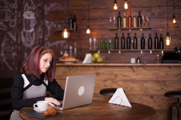 A person working on a laptop while sitting in a coffee shop. The ambiance is relaxed, and the person appears focused on their work. This image represents the flexibility and adaptability required to succeed in navigating Labor Market Trends: How to Navigate the Current 3.7% Unemployment Rate.